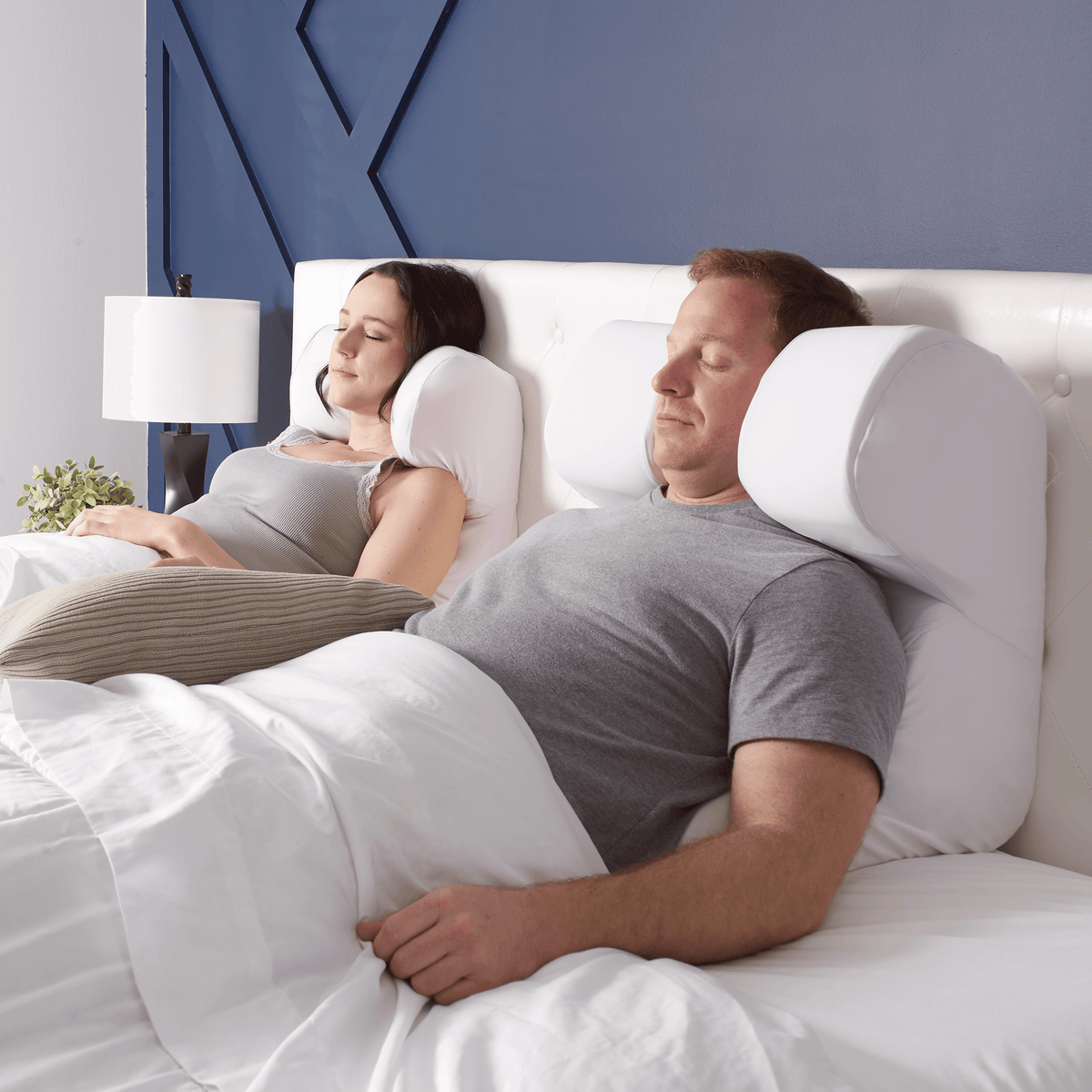 Couple sleeping peacefully with the Restinator sleep-support pillow