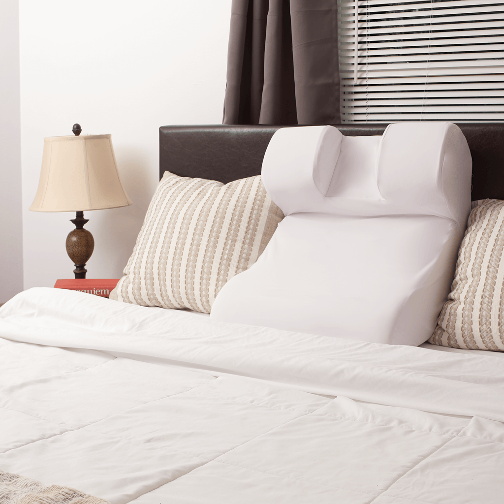 The Restinator pillow set up against a headboard