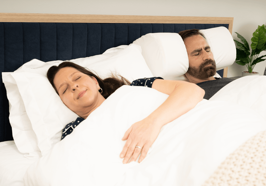 Couple sleeping peacefully—no more snoring—with the Restinator pillow